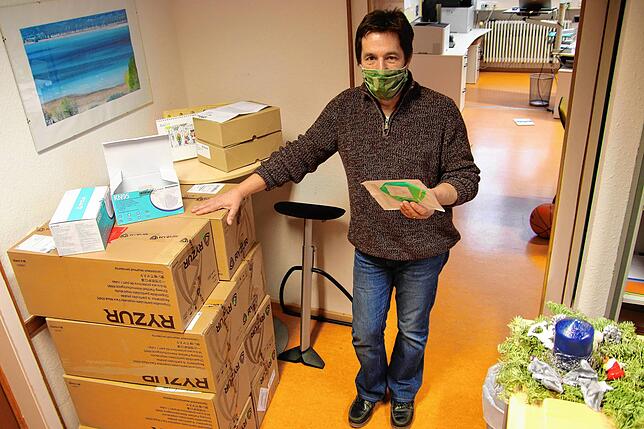 Frank Raddatz neben den acht Masken-Kartons vom Land im Sekretariat der Theodor-Heuss-Schule.