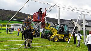 Rund 50 Helfer stellen am Samstag unter technischer Unterstützung von Radlader und Traktoren das Zelt für das Jubiläumsfest auf. Bild: ...