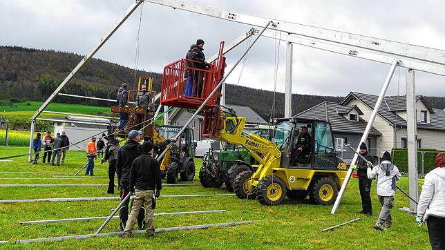 Rund 50 Helfer stellen am Samstag unter technischer Unterstützung von Radlader und Traktoren das Zelt für das Jubiläumsfest auf. Bild: ...