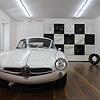Das schlägt das Herz höher: ein Alfa Romeo Guilia Sprint-Speciale. Im Hintergrund "Pole Position", das aus Motorhaben besteht.