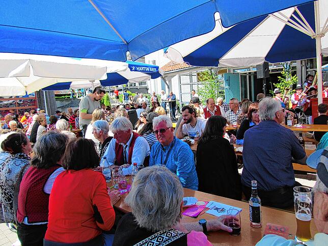Zur Mittagszeit sind schon viele Besucher auf dem Vorplatz der Randenhalle und genießen unter Sonnenschirmen die Festatmosphäre.