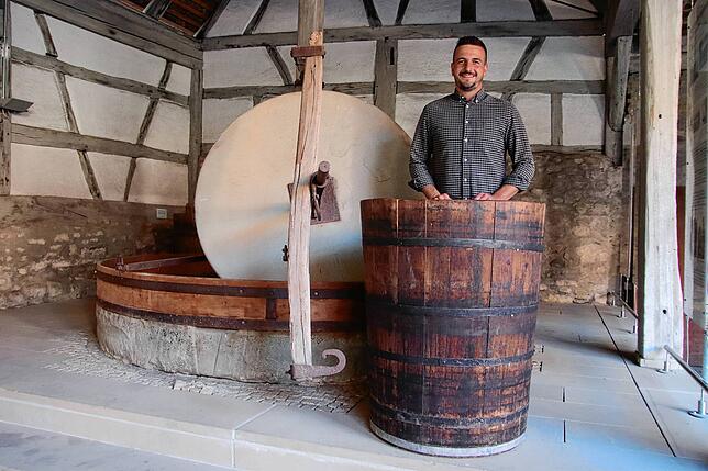 Die Weinpresse in der historischen Herrentorkel in der Ortsmitte. Lukas Fehringer steht in dem denkmalgeschützten Gebäude.