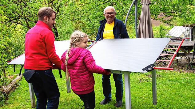 Der Sonne entgegen: Florian Gutmann und seine Tochter Marika (vorne) drehen ein mobiles Balkonkraftwerk für eine bessere Stromausbeute ...