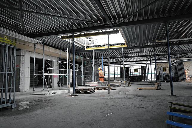 Auf der „Schwaben“-Migros-Baustelle blickt ein Arbeiter durch eine Luke im Dach des ersten Obergeschosses. Durch sie soll ...