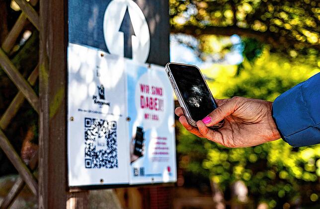 Eine Frau registriert sich auf der Insel Sylt mit einem Smartphone und der Luca-App als Besucherin eines Restaurants. Die Gemeinde Sylt ...