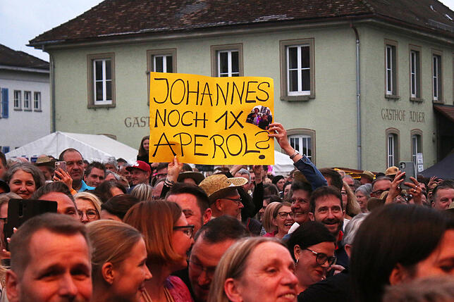 Johannes Oerding sucht das Gespräch mit den Fans. Mit diesen Schildträgern hat er einst in Karlsruhe Aperol getrunken.