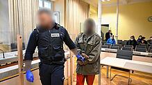 Der 32-jährige mutmaßliche Täter wird in Handschellen von einem Justizmitarbeiter zur Anklagebank geführt. Die Aufnahme entstand am 27. ...