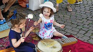Sie trommeln und vergnügen sich mit den verschiedenen Musikinstrumenten der Kinderkantorei Hochrhein.