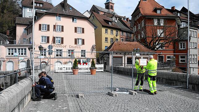 Polizeibeamte und Mitarbeiter der Technischen Betriebe Laufenburg installieren auf der Laufenbrücke einen Gitterzaun, der ...