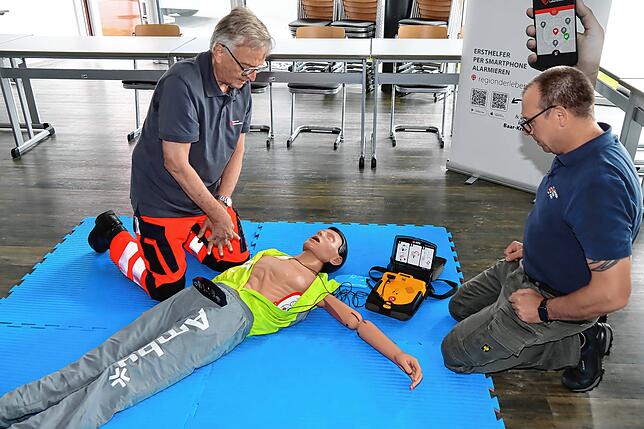 Die Ersthelfer Johannes Kohler und Gerhard Maier haben sich vom Patienten entfernt und warten die Schockabgabe durch das ...