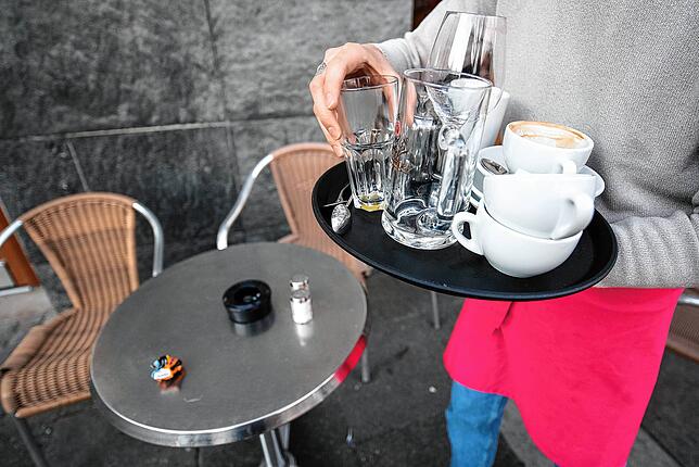 Ein Kellner räumt einen Tisch in einem Restaurant ab. Die Branche leidet unter Fachkräftemangel.