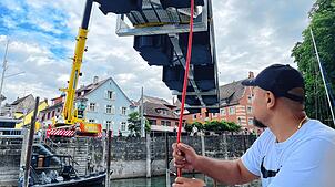 Der Mitarbeiter von Lutz Ackermann nimmt einen Stegteil im Hafenbecken entgegen. Jedes der neun Teile ist so geformt, dass es an der ...