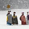Als Heilige Drei Könige und Sternträger verkleidete Kinder stapfen wacker durch den Schnee in Oberösterreich.