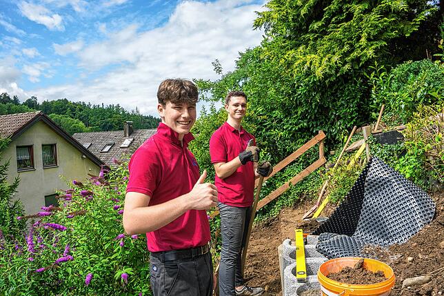 Moritz König (links) und Linus Zwetschke arbeiten im Garten einer Kundin in Tettnang.