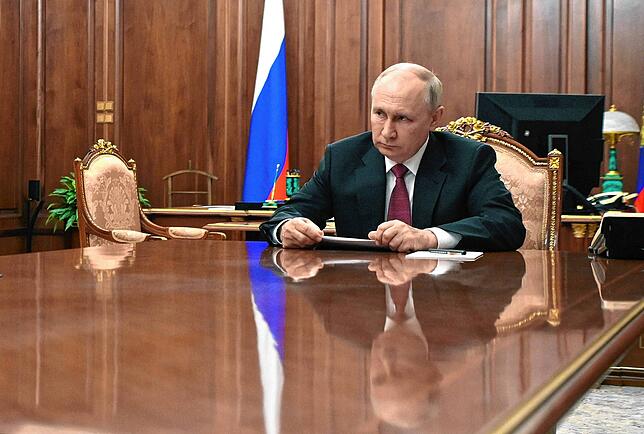 Wladimir Putin sitzt während einer Konferenz an einem Tisch im Moskauer Kreml. Der Schriftsteller Wladimir Kaminer meint: Irre ist Putin ...
