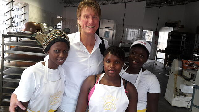 Der Unternehmer Michael Junginger steht mit drei Auszubildenden in der Sunshine Bakery in Tanji, Gambia.