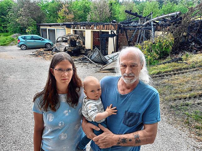 Erschüttert am Tag nach der Brandstiftung: Aline Widmann und ihr Vater Clemens Oßwald, der auf seinem Arm Alines Söhnchen Gabriel trägt, ...