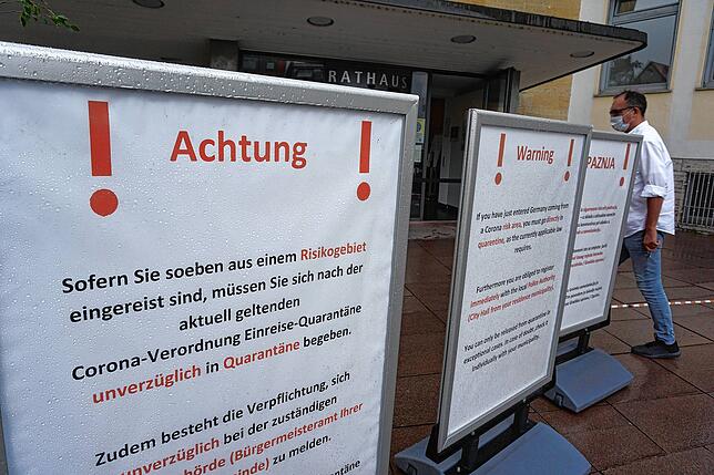 Vor dem Rathaus Friedrichshafen weisen übergroße Aussteller Reiserückkehrer aus Risikogebieten auf ihre Pflichten laut Corona-Verordnung ...