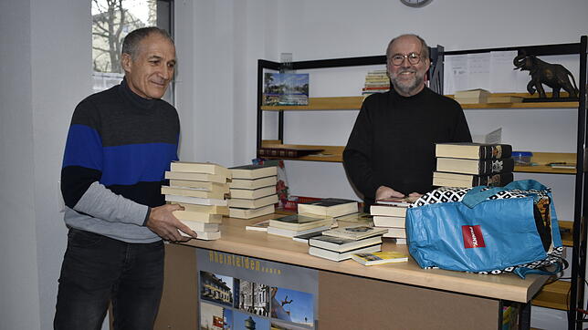 Wolfgang Ehrl (rechts) und Thomas Eichin sortieren und verräumen Bücher im Büchertausch an der Nollinger Straße.