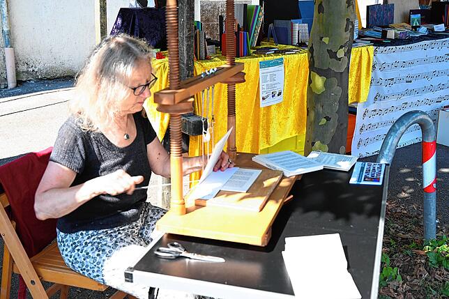 Die Buchbinderin Iris Haischer aus Freiburg zeigte an einer Heftlade das Fadenheften von Buchseiten im Gegensatz zur Klebebindung. ...
