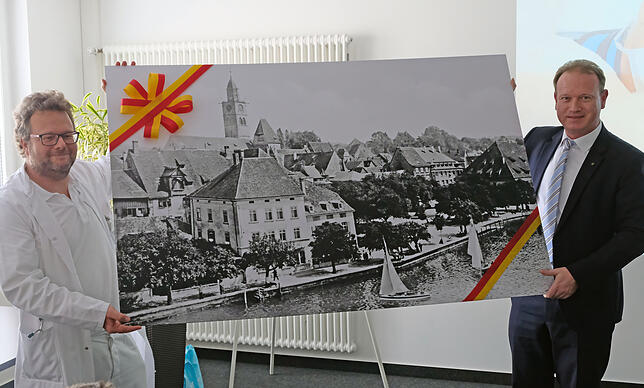 Eine historische Aufnahme von Überlingen hatte Oberbürgermeister Jan Zeitler mitgebracht und überreichte diese Chefarzt Marc Riemer.