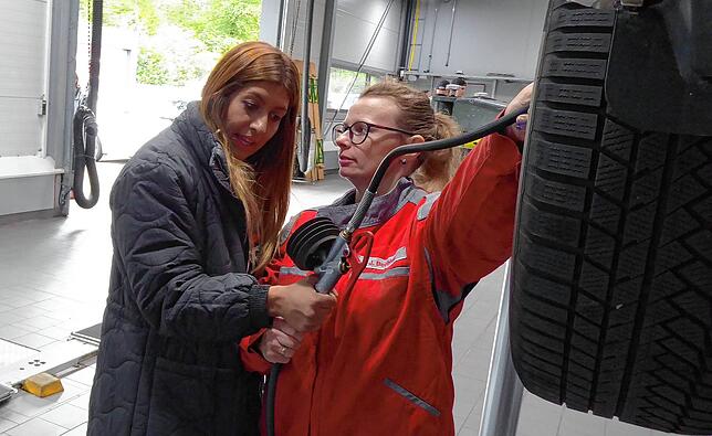 Mechanikerin Sabrina Spiegelhalter erklärt Dragana Reccia, wie man beim Auto den Reifendruck prüft.