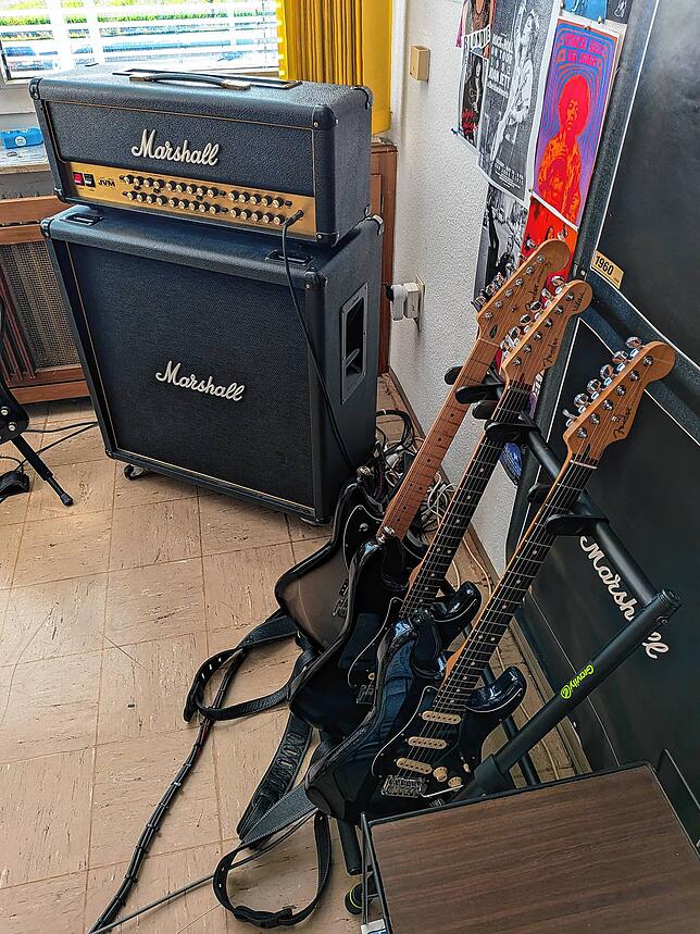 Im Proberaum stehen Gitarren griffbereit.