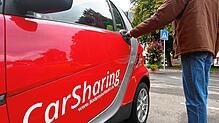 Ein Smart zum Teilen: Ein Passant greift nach der Tür eines Carsharing-Fahrzeugs auf dem Parkplatz vor dem Hotel Ochsen am Mantelhafen ...