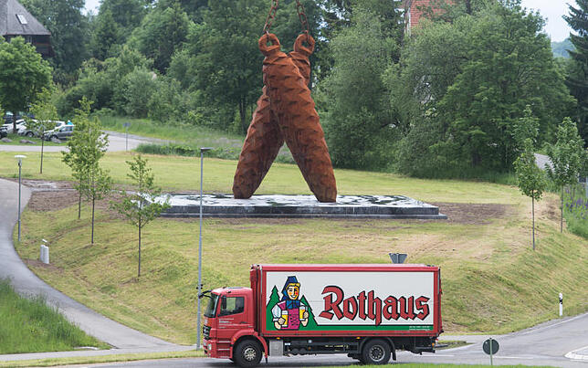 Ein Lkw der Staatsbrauerei Rothaus fährt in Rothaus an dem 15 Meter hohen Kunstwerk mit zwei Tannenzapfen von Stefan Strumbel vorbei.