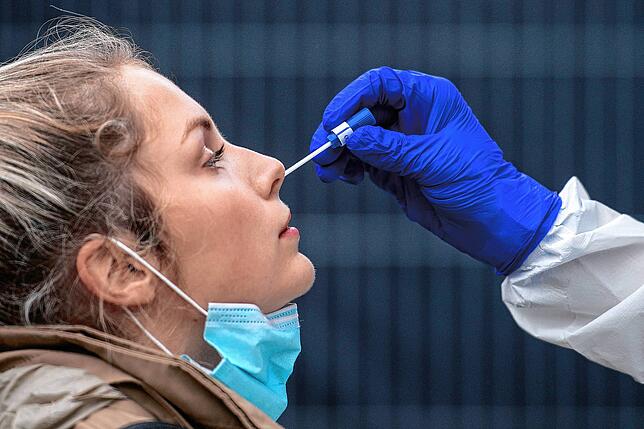 Eine Frau bekommt einen Nasenabstrich an einer Corona-Teststation. Die Zahlen steigen dramatisch und steuern auch im Landkreis Waldshut ...