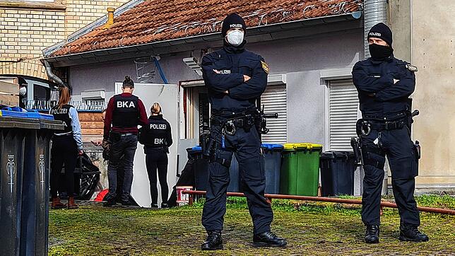 Polizisten stehen vor einem Hintereingang eines Gebäudes in Eisenach (Thüringen), das sie durchsuchen. Ermittler gingen am ...