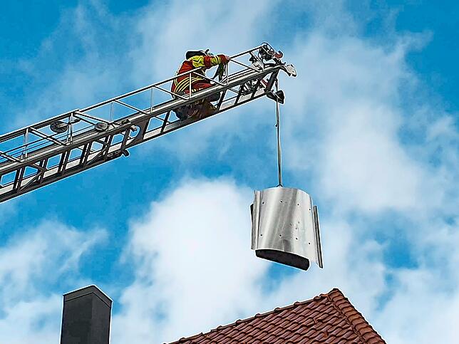 Mit der Drehleiter geht es beim Schonacher Ramselhof aufs Dach, wo der Sturm den Kaminhut gelöst hat.