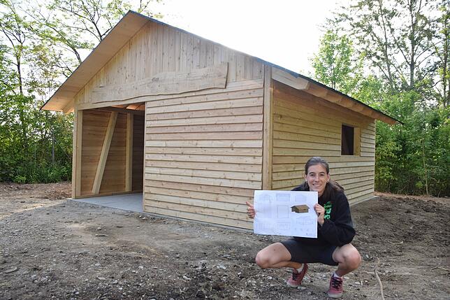 Organisatorin Ann-Kathrin Ritter mit dem Plan vor der fertigen Schutzhütte auf dem Kohlplatz vor Markelfingen.