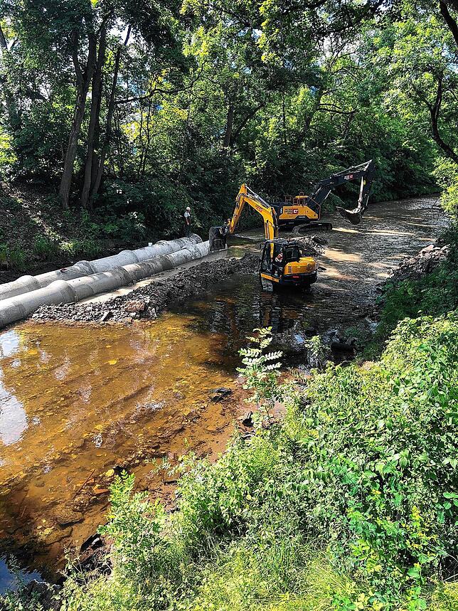 Zwei Bagger arbeiten gleichzeitig im Bach in Höhe des Bahnhofs.