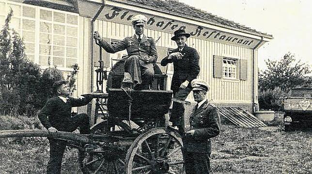 Diese Aufnahme zeigt vermutlich Teilnehmer der Deutschland-Tour von 1937 mit einer alten Kutsche vor dem Flughafen-Restaurant. Zwei der ...