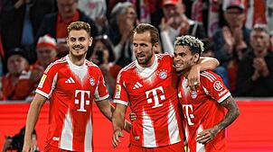Harry Kane (M, Bayern München) jubelt mit Josip Stanisic (l, Bayern München) und Luis Diaz (Bayern München) über sein Tor zum 5:0.