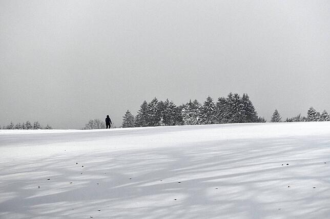 Ein einsamer Wanderer in der Schneelandschaft.