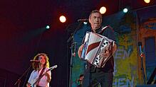 Weltmusiker Hubert von Goisern steht im Salemer Schlosspark auf der Bühne. Die Harmonika ist nur eines der Instrumente, die er spielt.