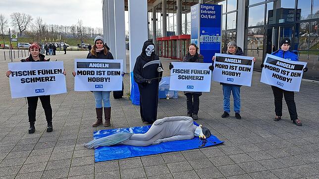 Ein Sensenmann hält die Angel über einem blutenden Karpfen. So sieht die Protestaktion der angereisten Aktivisten von Peta gegen die ...
