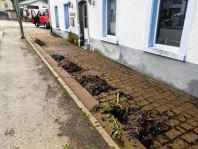 Schlammhäufchen säumen die Fußgängerwege entlang der Brückenstraße (B314) in Grimmelshofen.