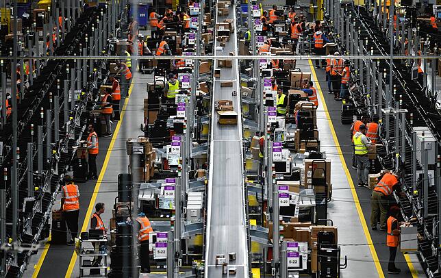 Angestellte in einem Logistikzentrum von Amazon. Der Versandhändler will mehr Mitarbeiter einstellen, um die zunehmenden ...