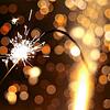 Eine große Wunderkerze brennt in der Silvesternacht vor einer gezündeten Silvesterrakete. Wegen der Corona-Pandemie gibt es dieses Jahr ...
