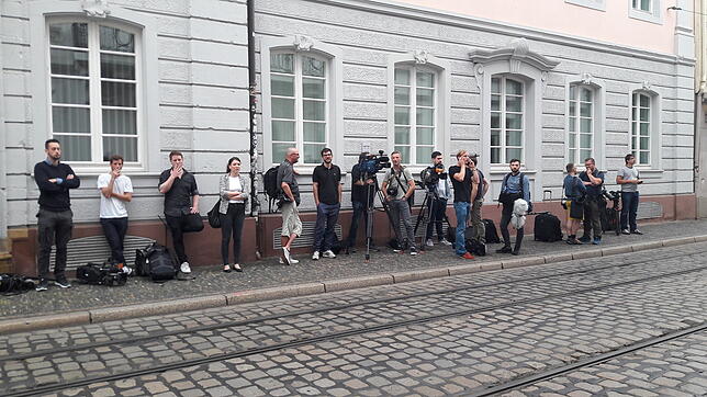 Bloß raus: Journalisten schnappen frische Luft in den kurzen Pausen der oft langen Verhandlungstage im Freiburger Landgericht. ...