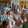 Singend begrüßen die Kinder die hinten sitzenden Gäste. Hinten rechts sitzt Ministerialdirektorin Isabel Kling (rote Jacke), links neben ...
