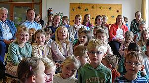 Singend begrüßen die Kinder die hinten sitzenden Gäste. Hinten rechts sitzt Ministerialdirektorin Isabel Kling (rote Jacke), links neben ...