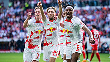Leipzigs Kevin Kampl (M) jubelt nach seinem Tor zum 0:1 mit Leipzigs Daniel Olmo Carvajal (l) und Leipzigs Mohamed Simakan (r).
