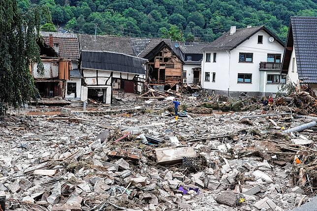 Rheinland-Pfalz, Schuld: Ein Mann steht nach dem Unwetter mit Hochwasser in den Schuttbergen.