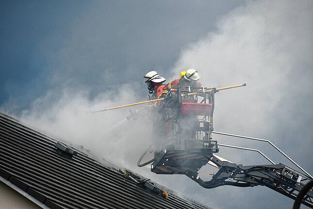 Atemschutzträger im Korb der Drehleiter: Sie öffnen das Dach für die Brandbekämpfung.