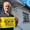 Ferdinand Ritzmann protestiert vor seinem Haus gegen den geplanten Übungsplatz im Wald bei Überauchen.