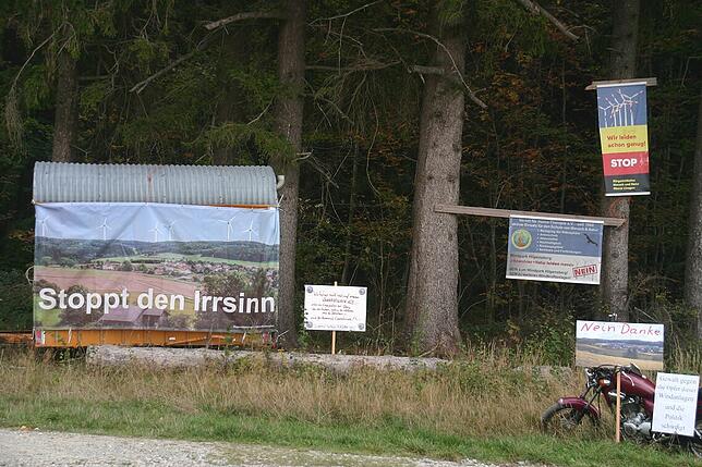 Mit Plakaten vor Ort protestieren die Windparkgegner gegen die bestehenden drei und die geplanten vier Windräder.
